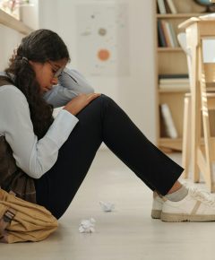 side-view-of-lonely-and-upset-african-american-schoolgirl-sitting-on-the-floor.jpg